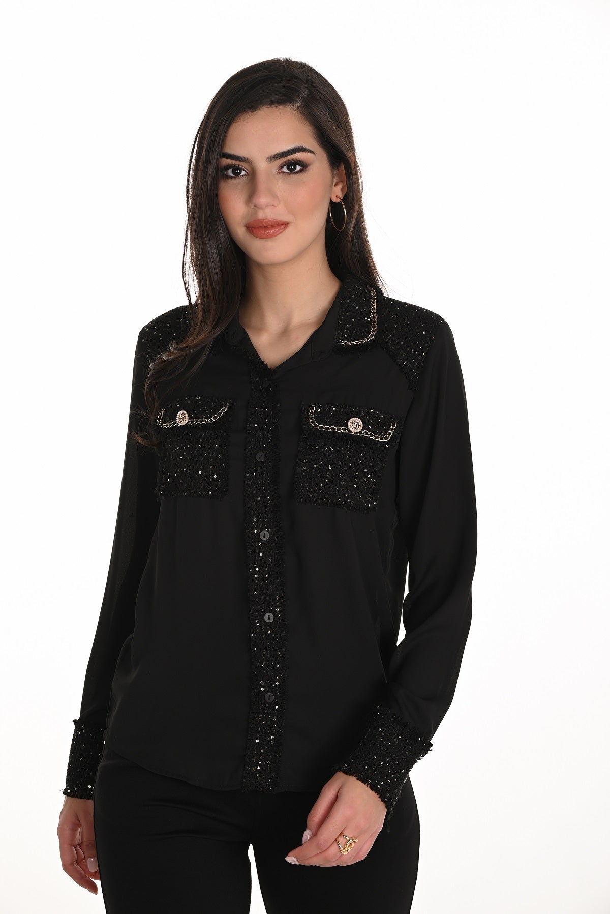 Woman wearing a black embellished shirt on a white background