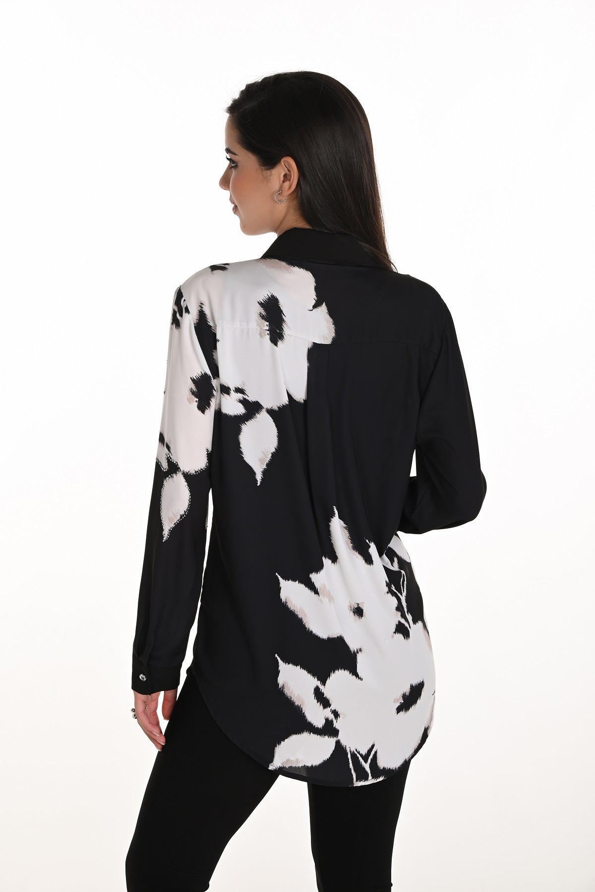 Woman wearing a black and white floral patterned shirt on a white background