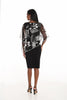 Woman wearing a black dress with sheer sleeves on a white background