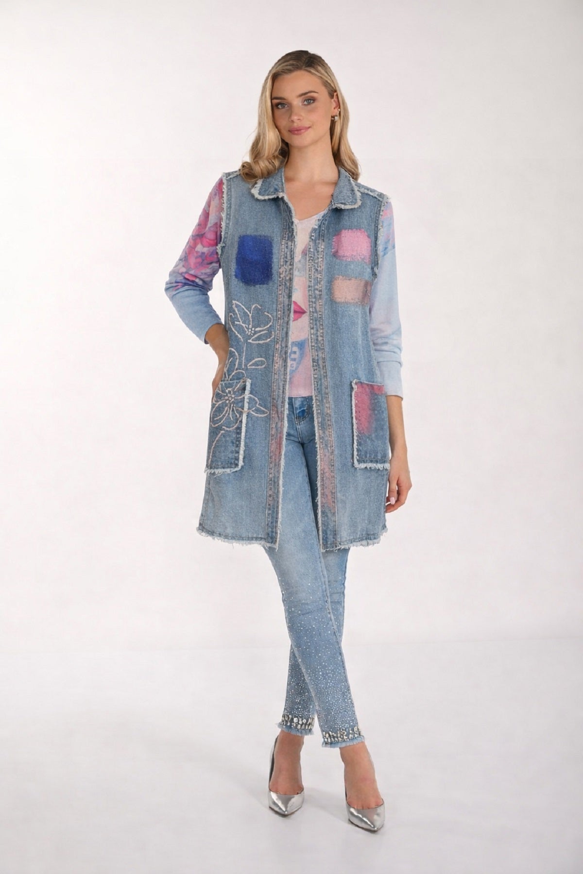 Long Sleeveless Denim Vest With Front accent Print and Frayed Detail in Light Denim Blue.