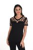 Woman wearing a black top with lace details on a white background