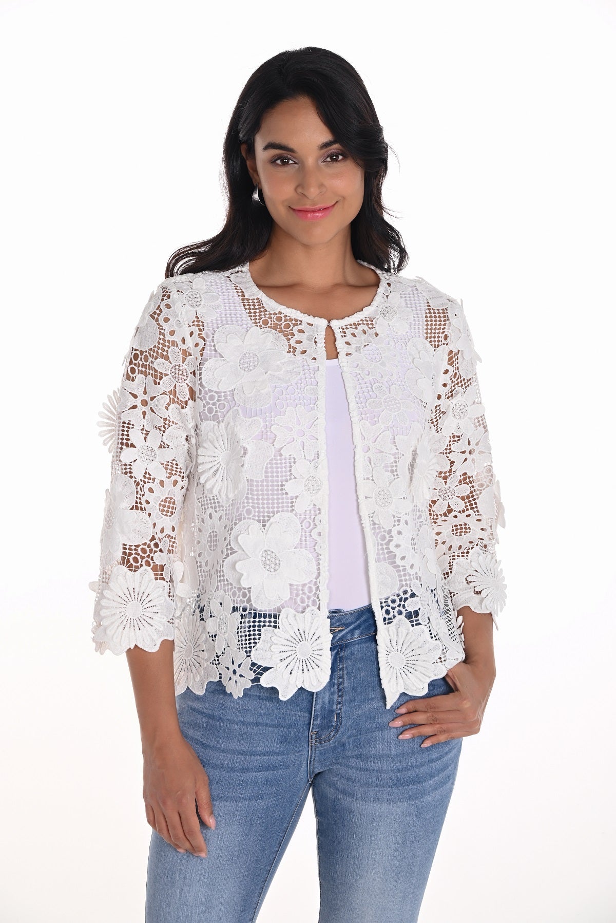 Woman wearing a white lace top and blue jeans on a white background