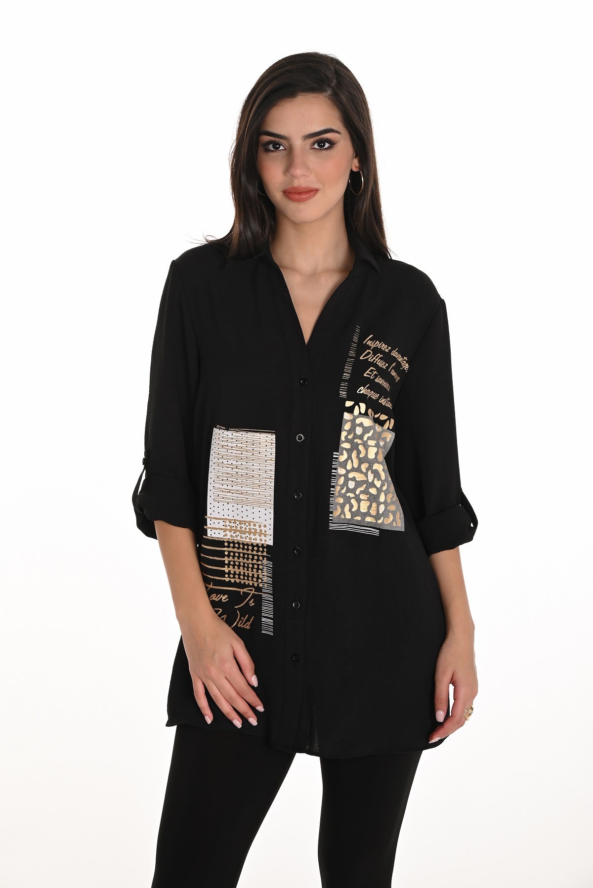 Woman wearing a black blouse with patterned patches on a white background