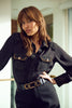 Woman wearing a black outfit with embellishments in an indoor setting