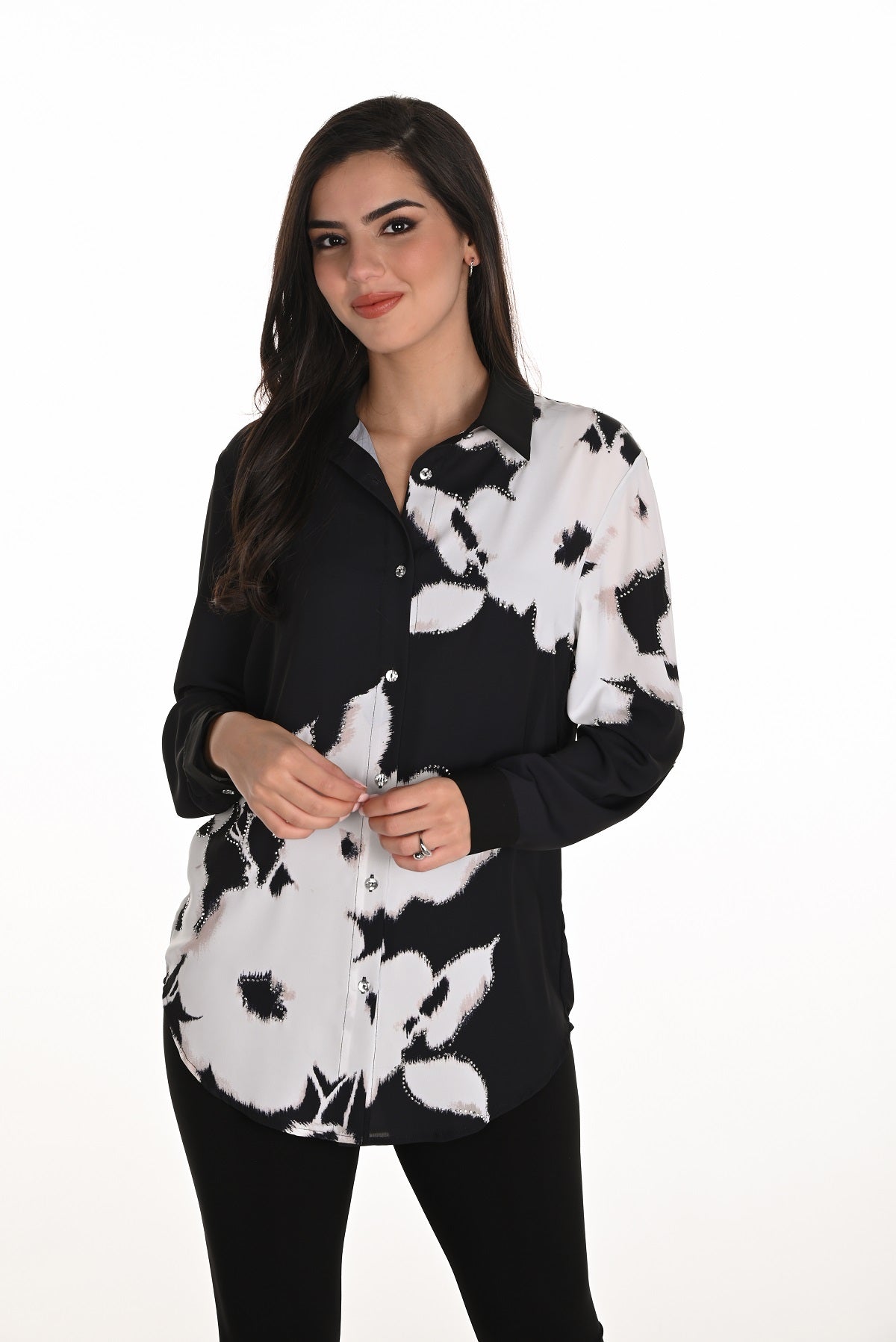 Woman wearing a black and white floral shirt on a white background