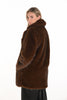 Woman wearing a brown fur coat on a white background