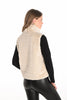 Woman wearing a beige puffer vest over a black long-sleeve shirt on a white background