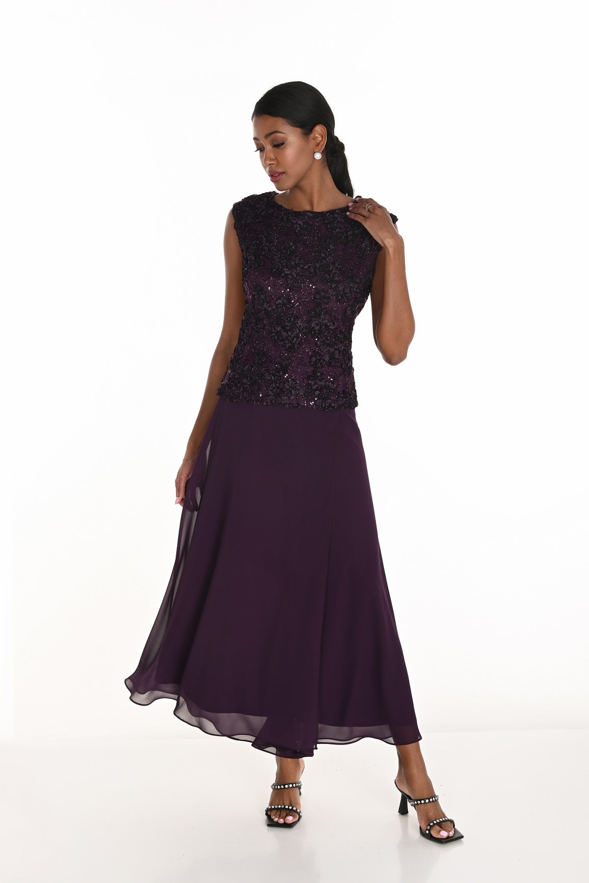 Woman wearing a purple evening gown with a sequined top on a white background