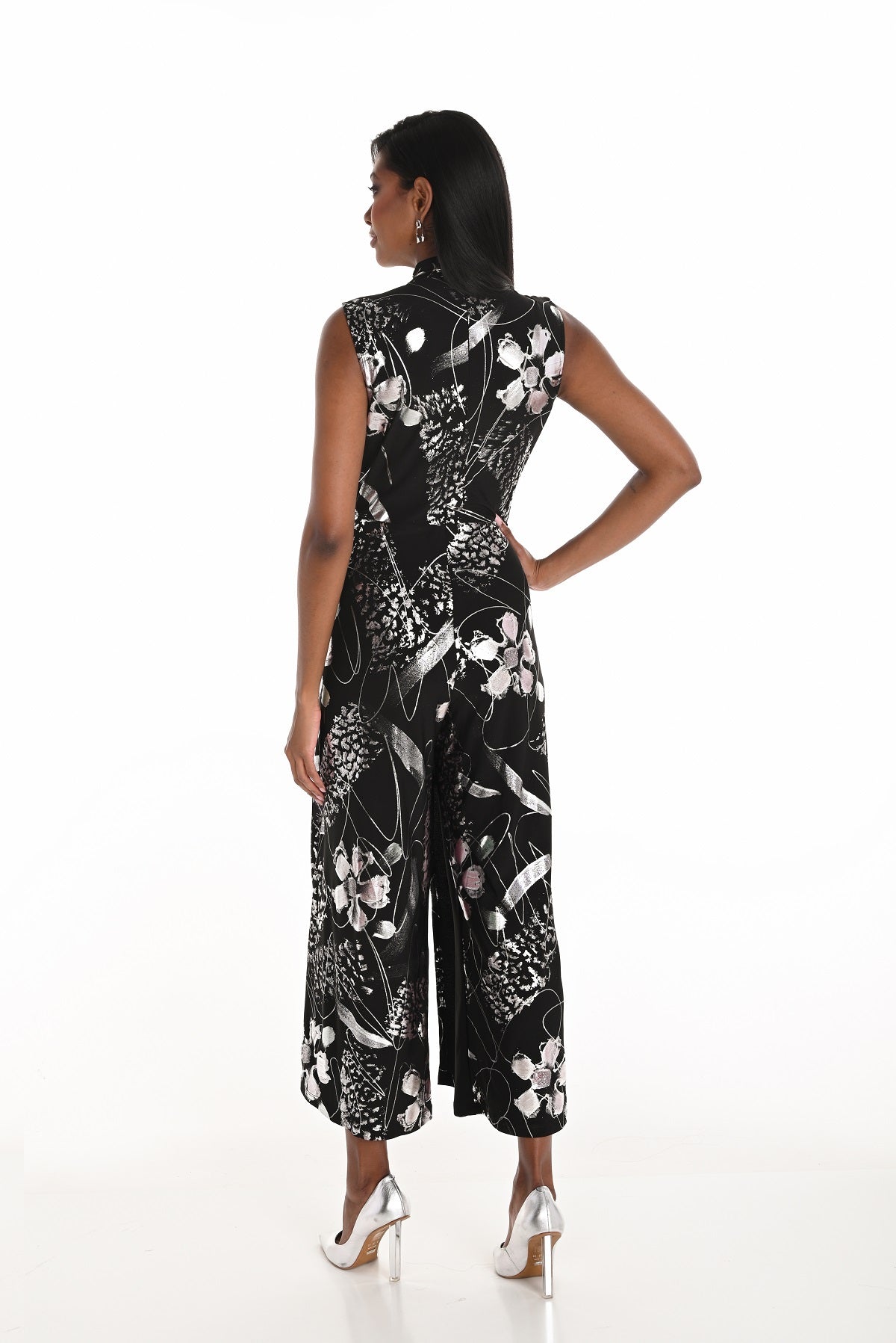 Woman wearing a black floral jumpsuit on a white background