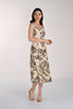 Woman wearing a sleeveless dress with a leaf pattern on a white background
