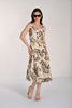 Woman wearing a sleeveless dress with leaf pattern on a white background