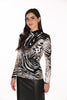 Woman wearing a black and white patterned blouse on a white background