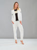 Woman wearing a white suit with a black top against a gray background