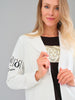 Woman wearing a white blazer with text on the sleeves against a gray background
