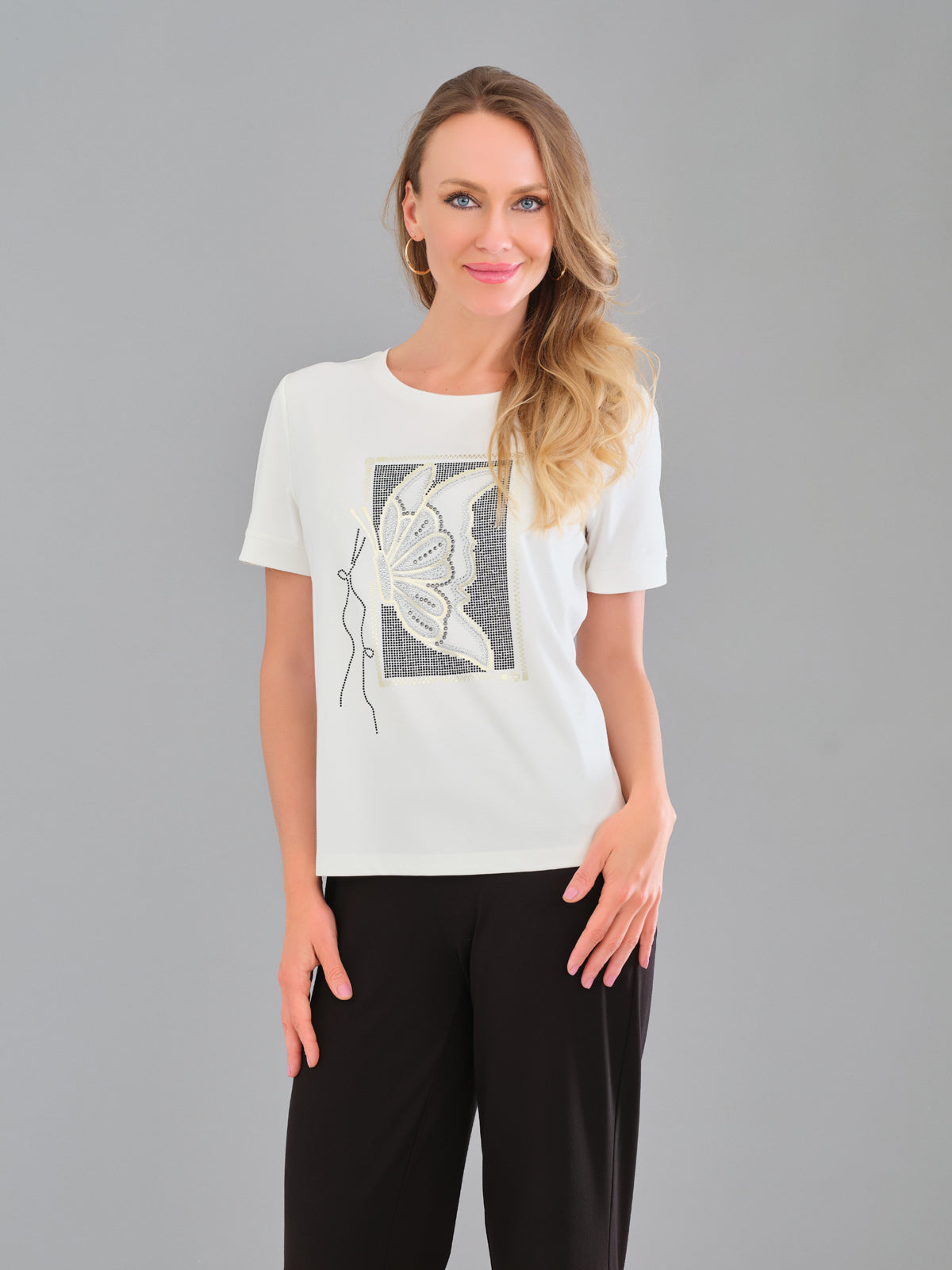 Woman wearing a white t-shirt with a graphic design on a gray background