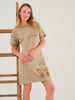 Woman wearing a beige dress with floral embroidery and 'Fashion' text on a white background