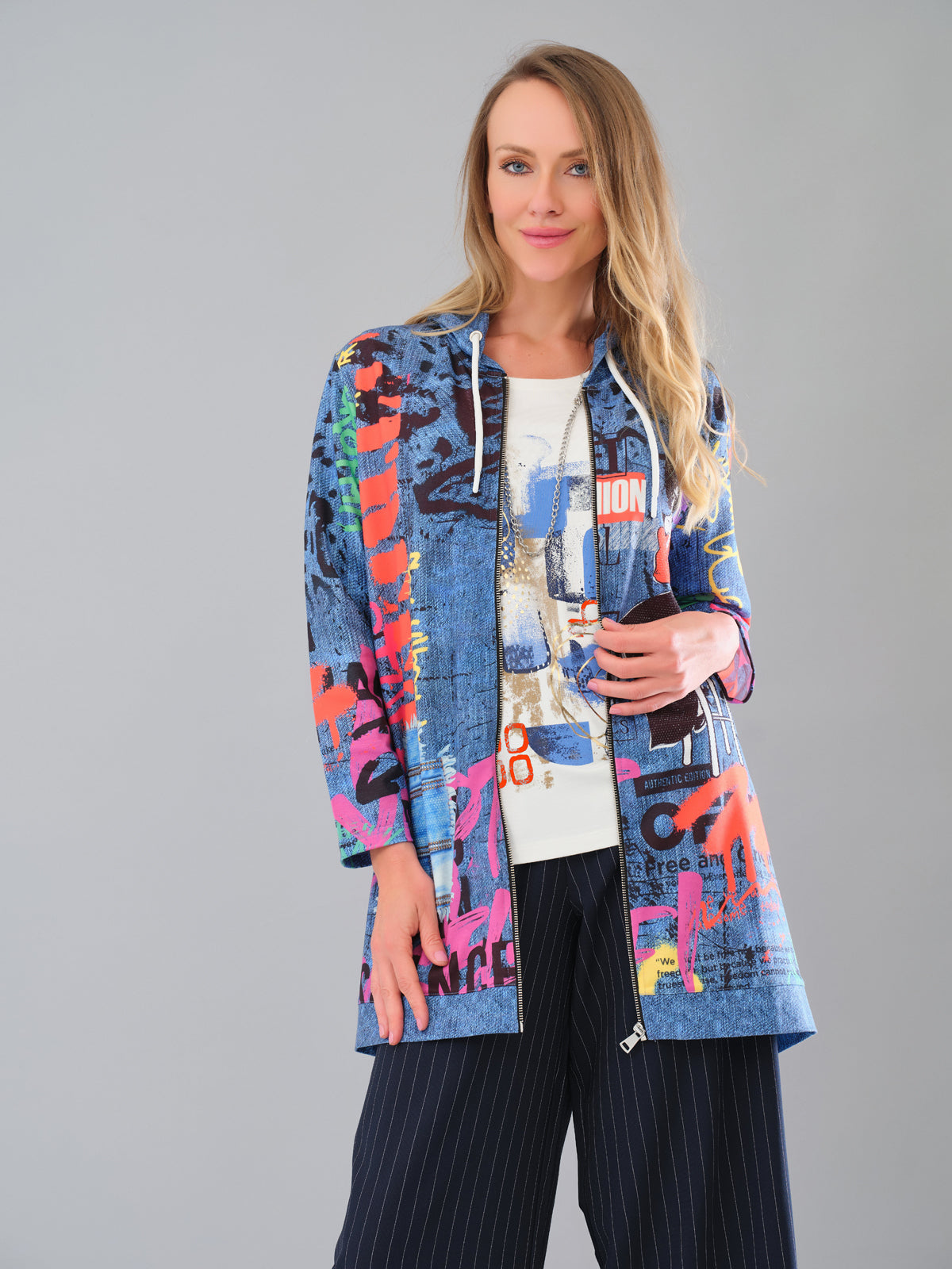 Woman wearing a colorful jacket with a gray background