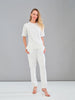 Woman wearing a white outfit against a gray background