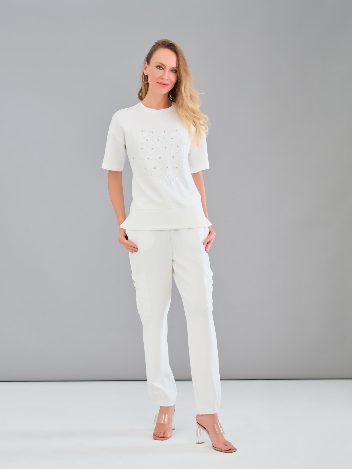 Woman wearing a white outfit against a gray background
