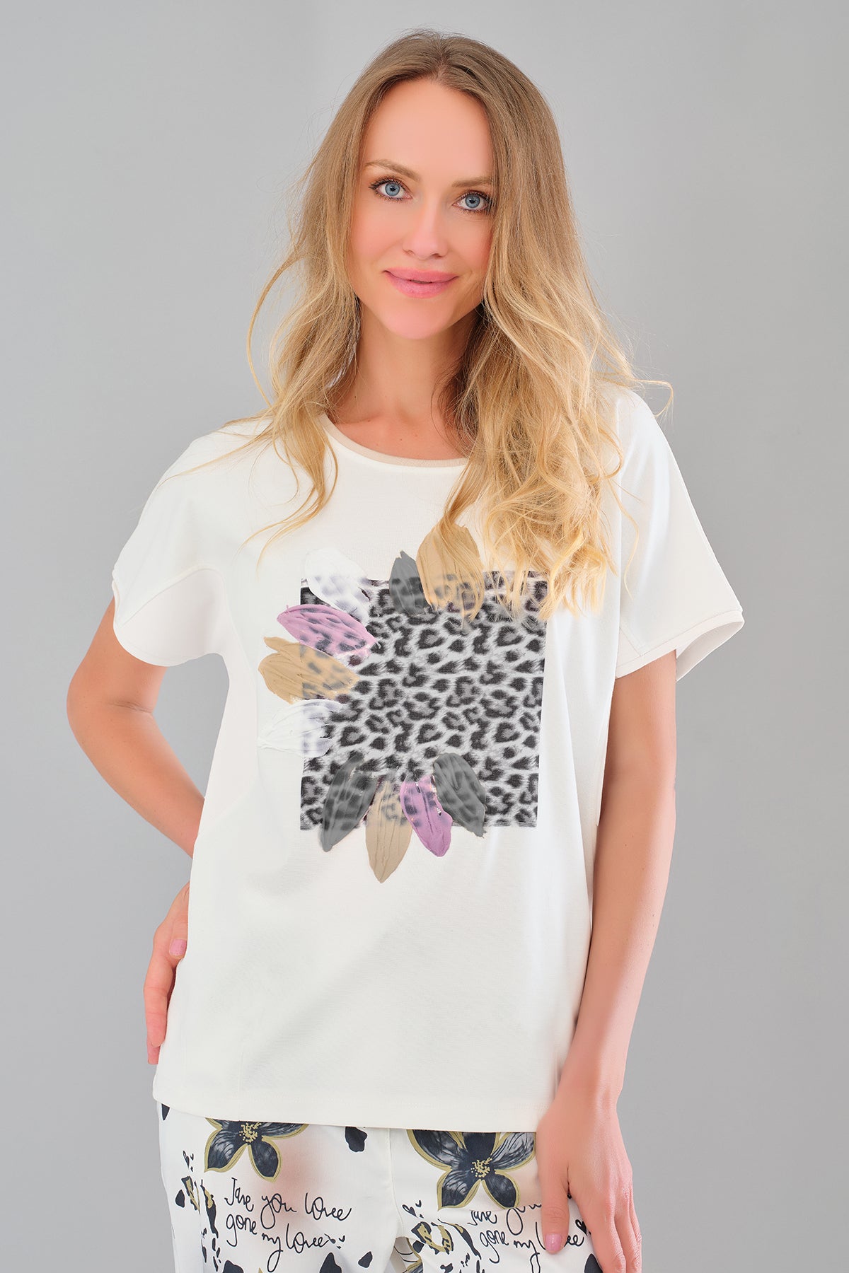 Woman wearing a white t-shirt with a graphic design on a gray background