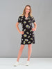 Woman wearing a black dress with floral pattern against a gray background