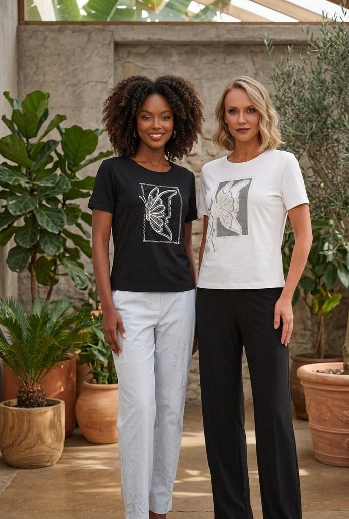 Two women standing outdoors with plants in the background