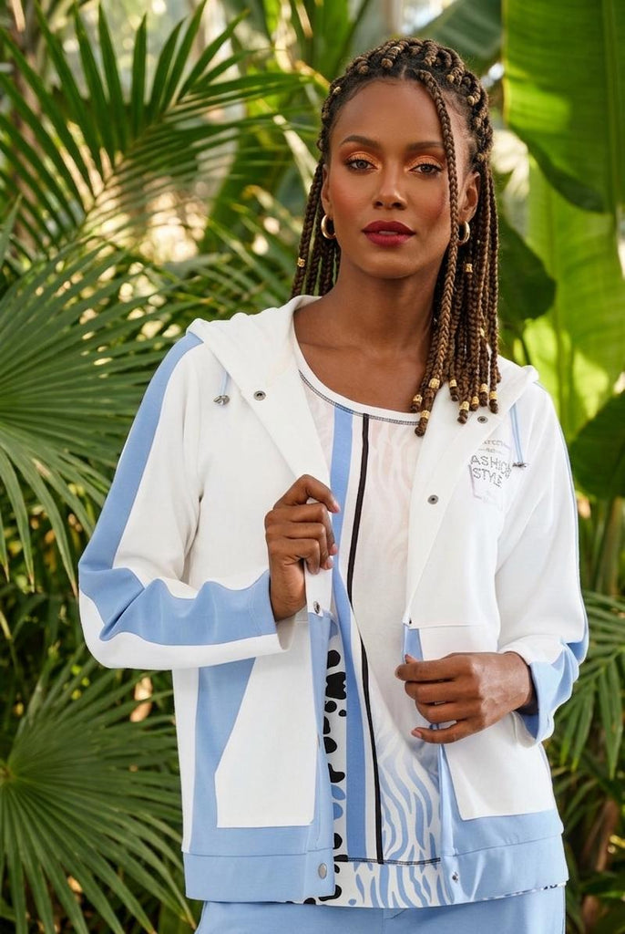 Woman wearing a light blue and white jacket with a tropical background