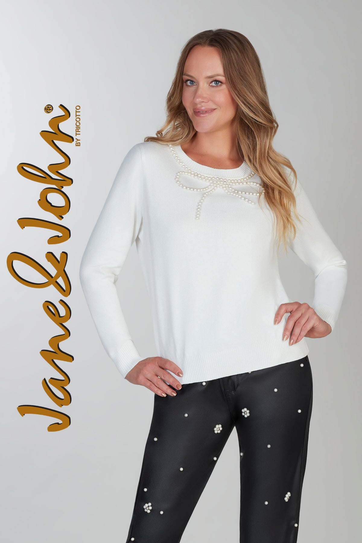 Woman wearing a white long-sleeve top and black leggings with white embellishments on a gray background, with 'Jane & John' branding.