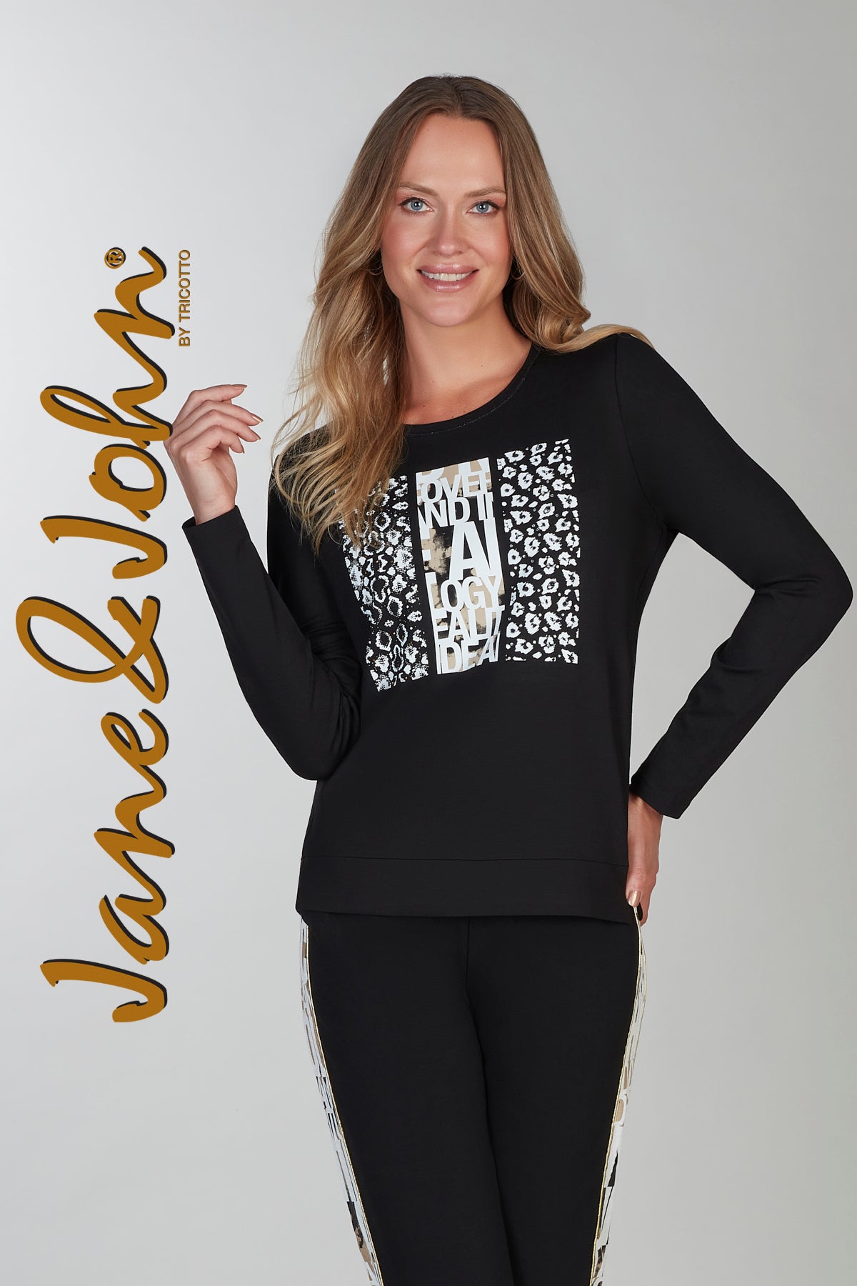 Woman wearing a black long-sleeve top with white text and leopard print, standing against a plain background. The brand 'Jane & John' is visible.