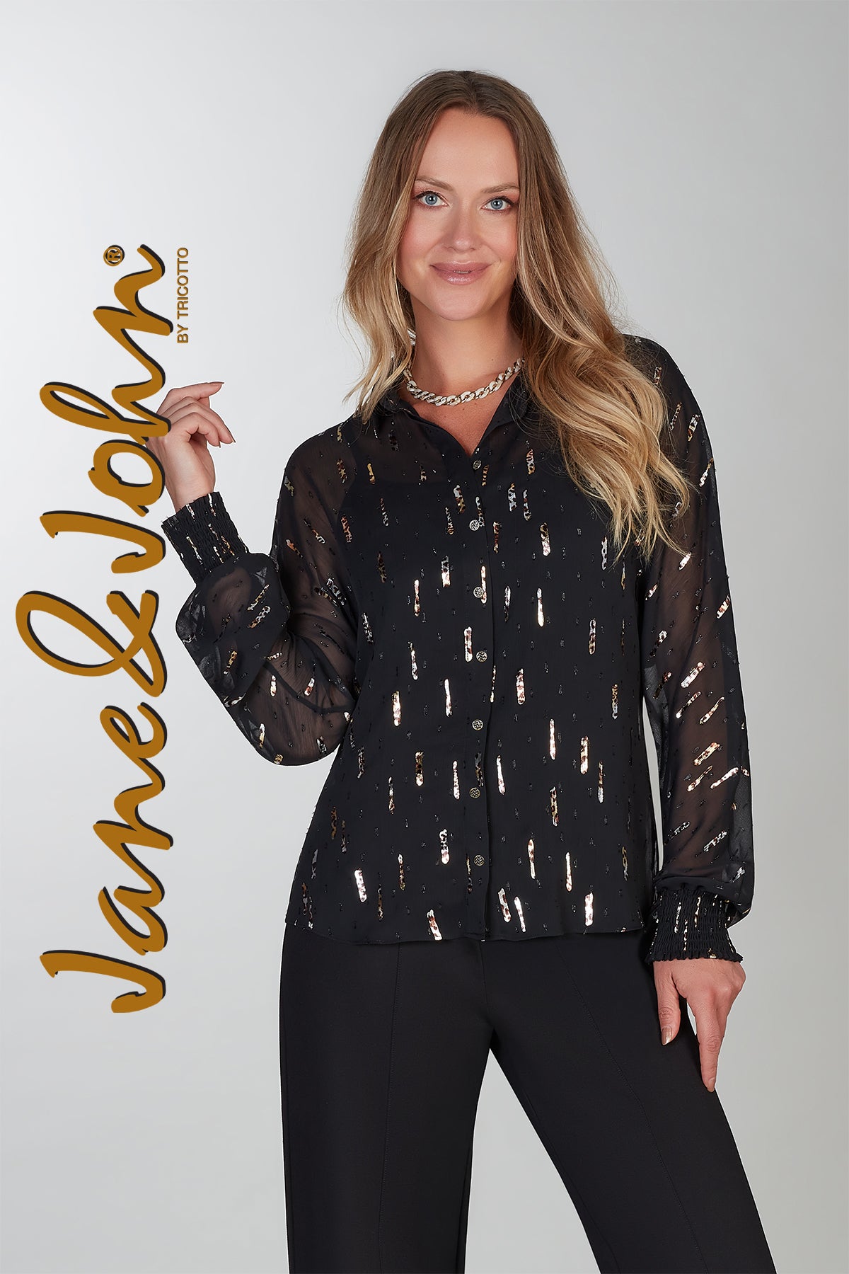 Woman wearing a black patterned blouse with 'Jane & John' branding on a white background