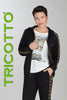 Person wearing a black hoodie and pants with decorative elements, holding a phone, on a gray background with 'TRICOTTO' branding.
