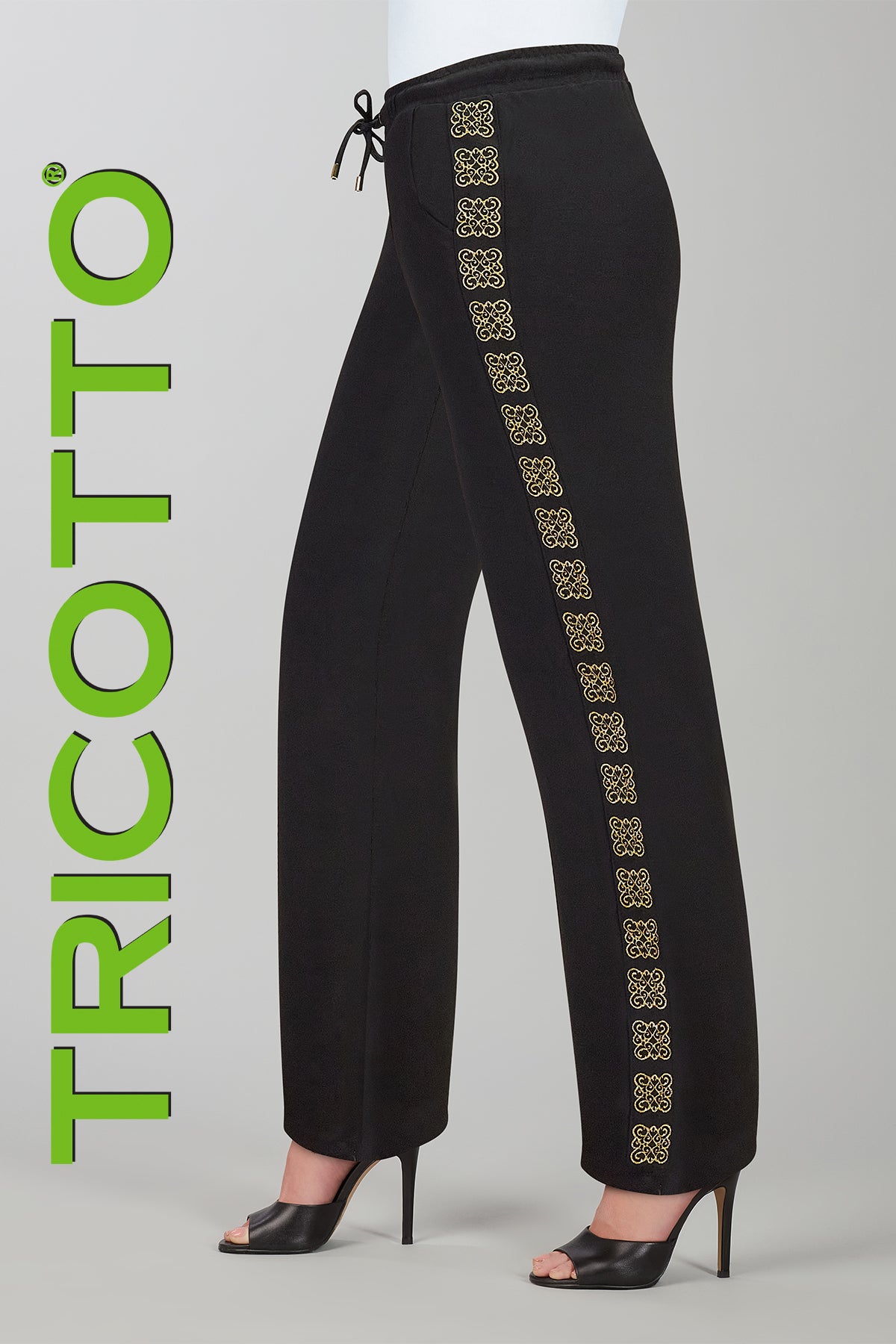 Black pants with gold embroidery on a gray background, featuring the brand 'Tricotto'.