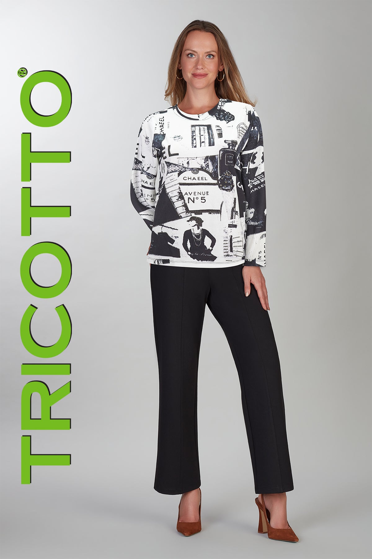 Woman wearing a black and white patterned top with black pants, standing against a gray background with 'TRICOTTO' branding.