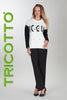 Woman wearing a black and white outfit with 'TRICOTTO' branding on a gray background