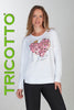 Woman wearing a white sweatshirt with floral design and text, standing against a gray background with 'TRICOTTO' branding.