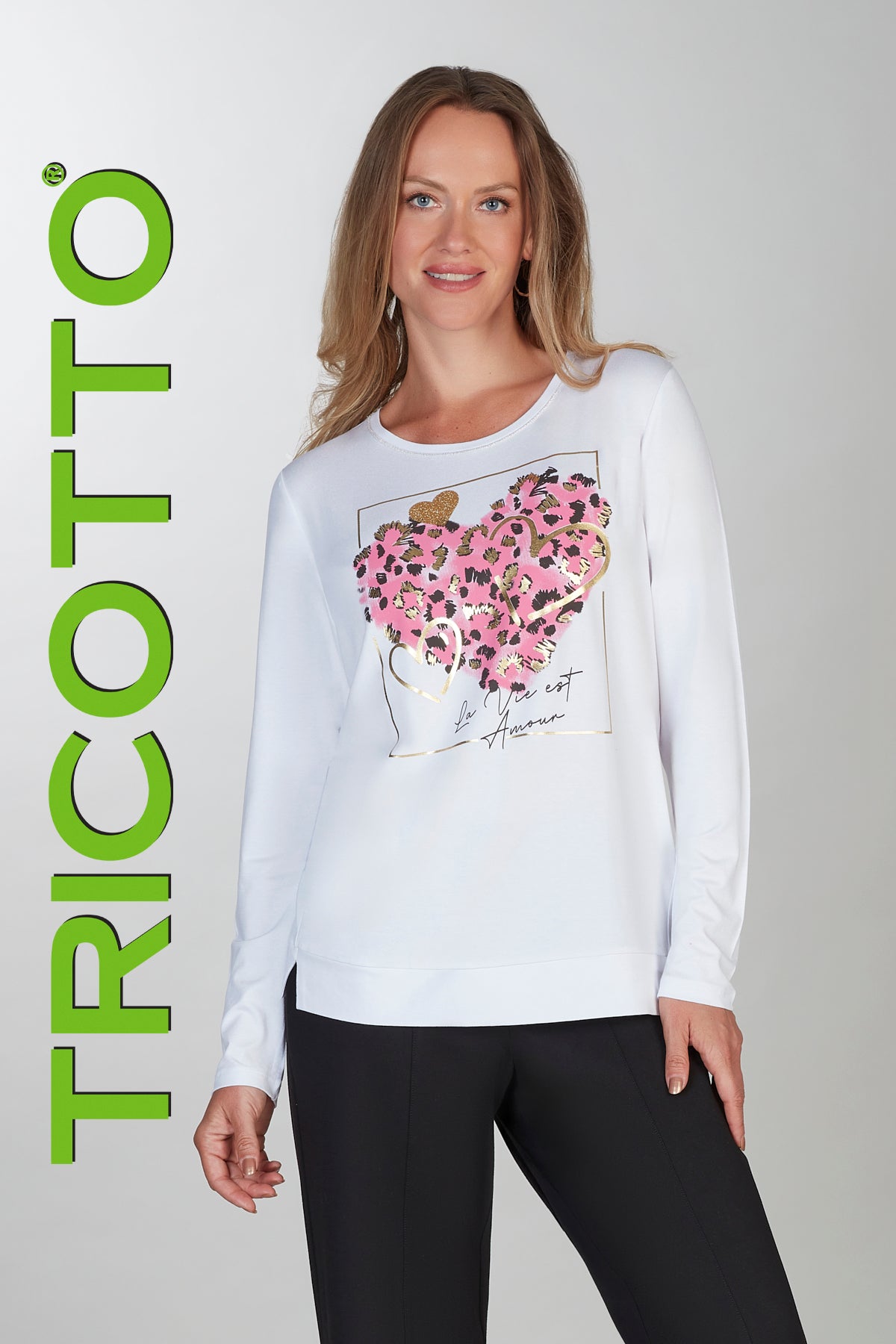 Woman wearing a white sweatshirt with floral design and text, standing against a gray background with 'TRICOTTO' branding.