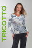 Woman wearing a patterned long-sleeve top with 'Tricotto' branding on a gray background